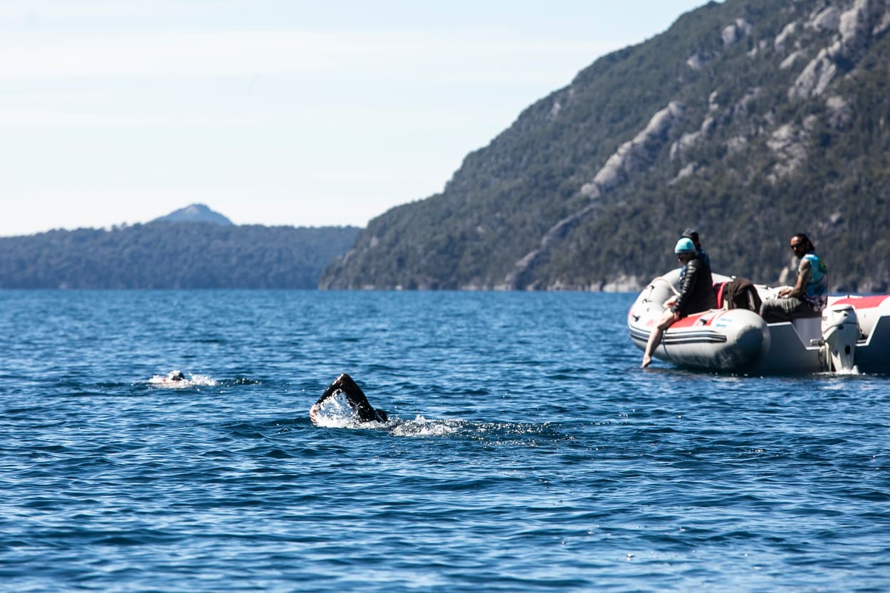 Nadadores y kayaks de apoyo en el lago Nahuel Huapi