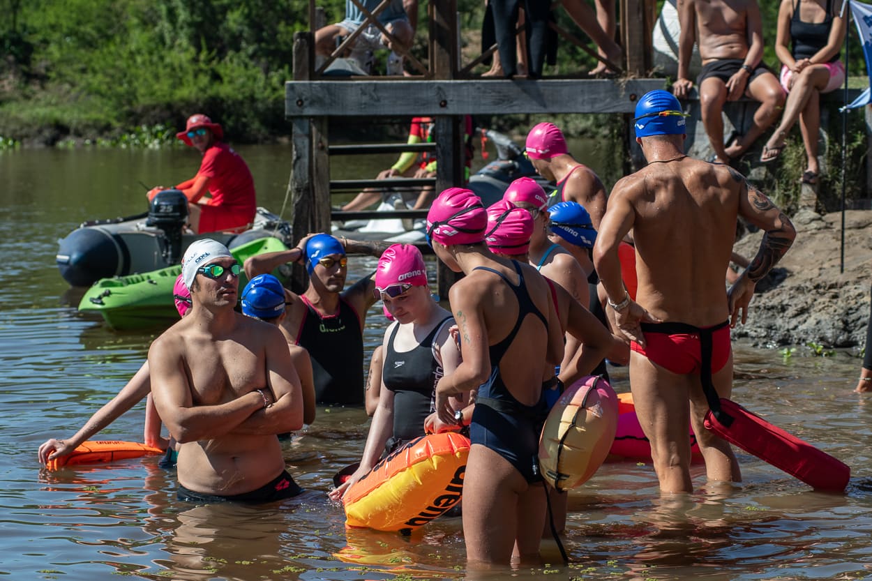 Grupo de jóvenes nadadores del PDA con boyas, listos para entrar al agua