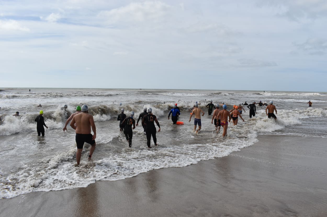 Nadadores metiéndose al mar entre olas grandes