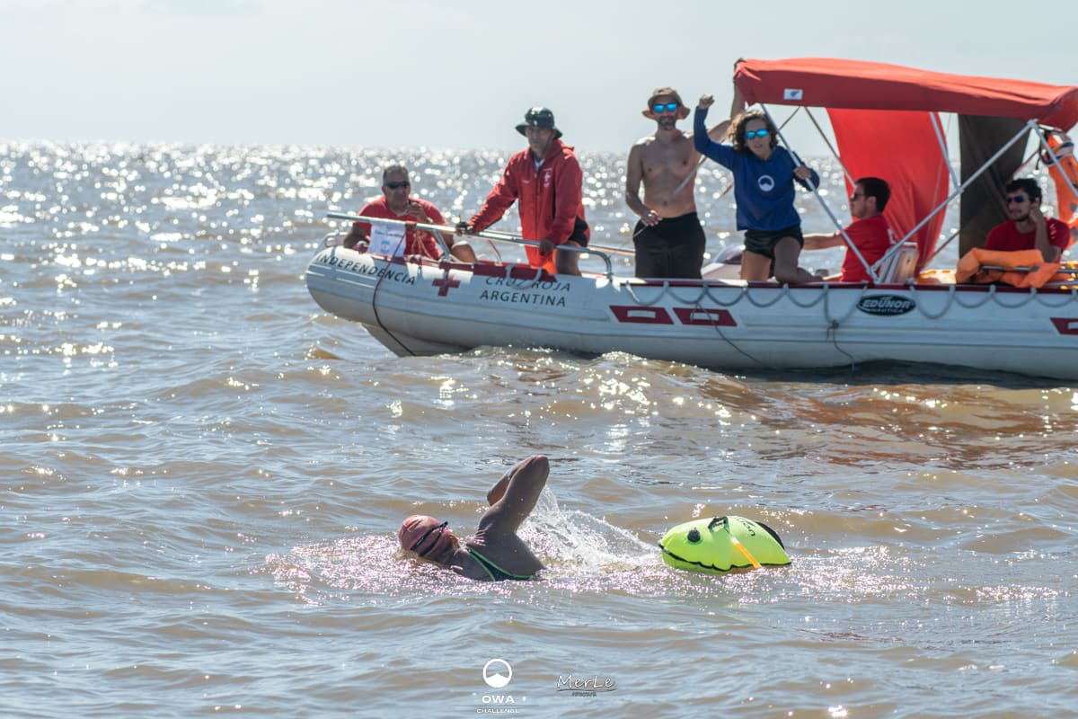 Nadador durante el cruce, con la lancha de apoyo al lado