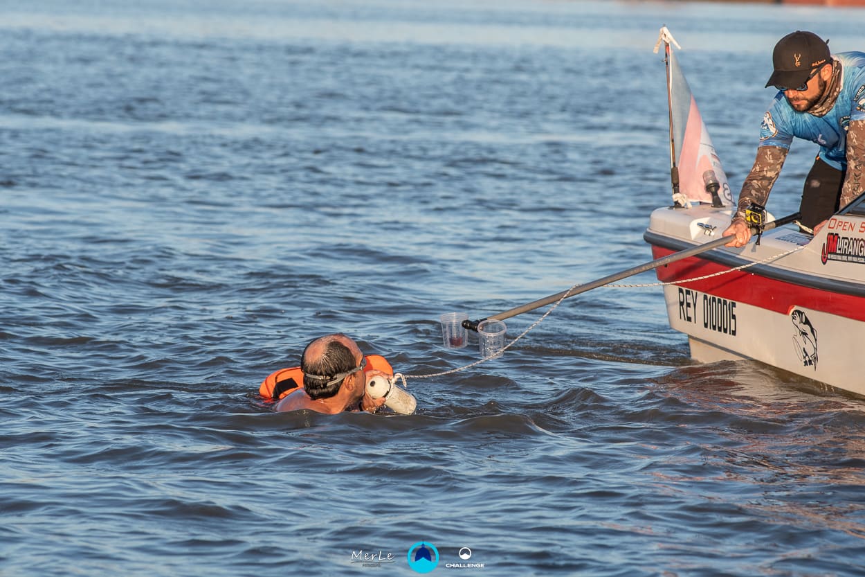 Nadador y embarcación de apoyo en el río Paraná