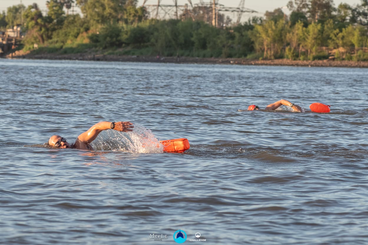 Nadador avanzando por el Paraná con la costa de fondo
